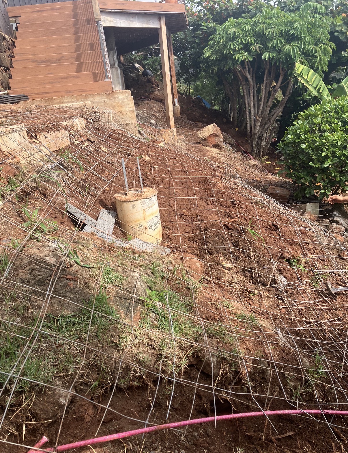 Reinforcing mesh and formwork progressing up a sloped backyard hillside