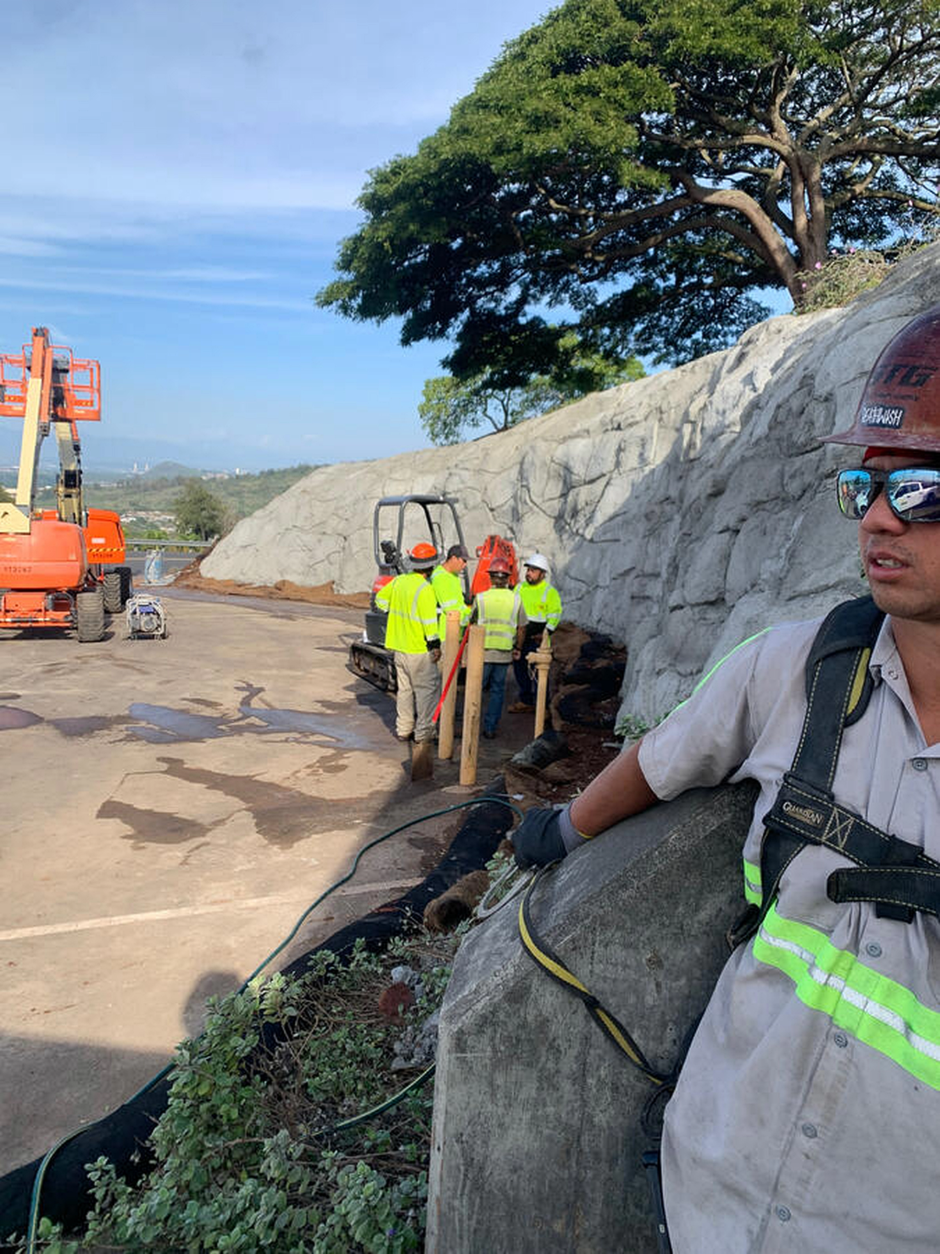 Crew beside a sculpted shotcrete wall at Kamehameha Schools