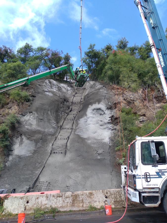 Equipment and crew working on a steep concrete slope at the Board of Water Supply project