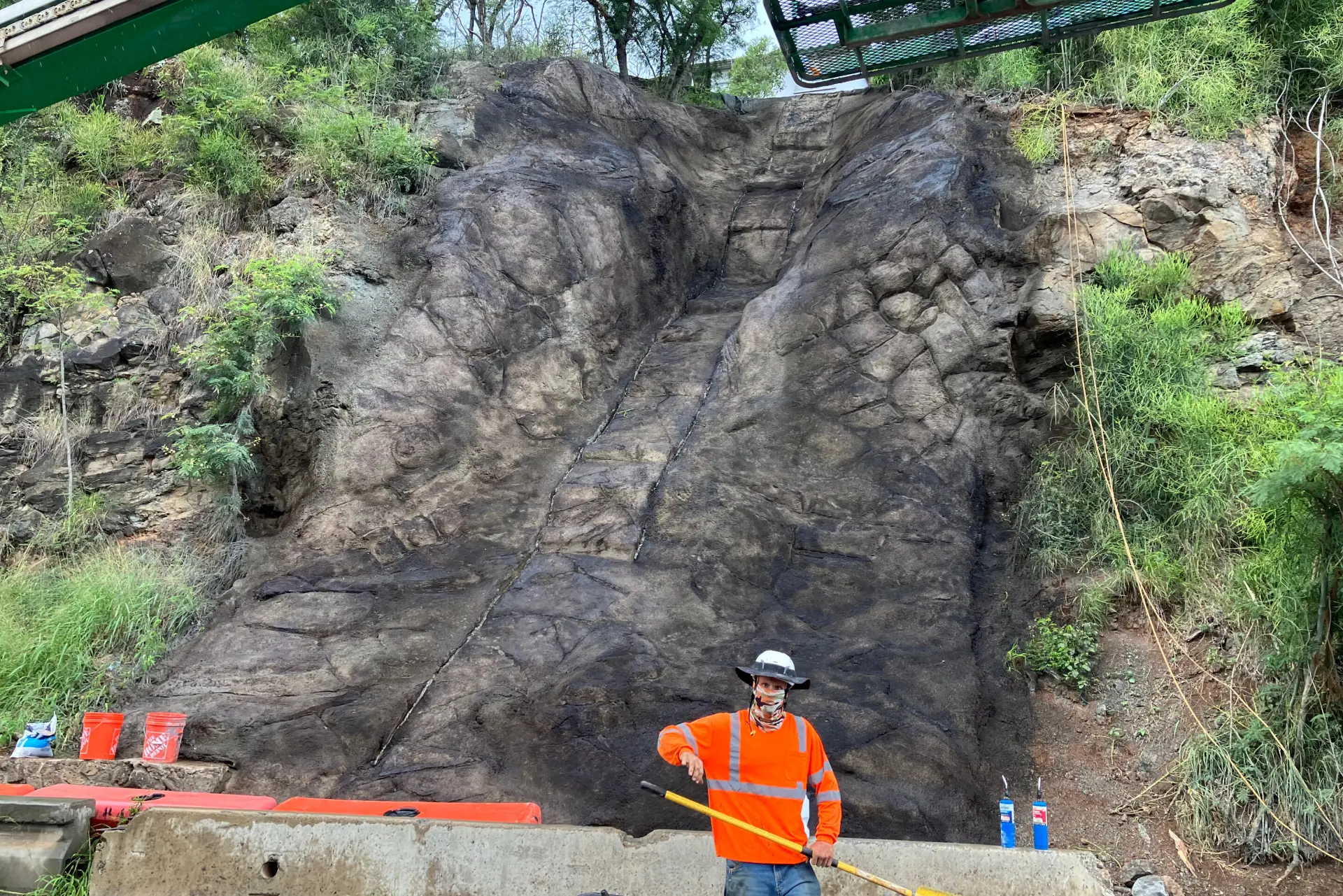 Worker in front of a sculpted concrete slope at the Board of Water Supply project